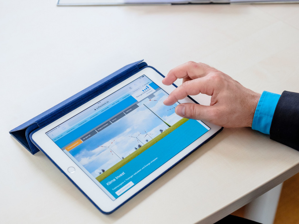 Informationen aus der Thüringer Aufbaubank (auf dem Bild zu sehen ist ein Tablet, das von einem Mann bedient wird.)
